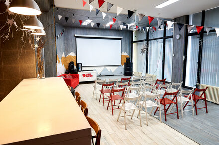 Стильный лофт в скандинавском стиле. Вход с улицы. Складные стулья, расставлены в формате конференции.