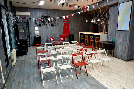 Стильный лофт в скандинавском стиле. Вход с улицы. Сладные стулья в формате конференции, вид зала со сцены.