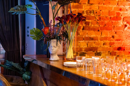 Лофт со сценой. Широкая барная стойка с барными стульями. Стол с едой и посудой