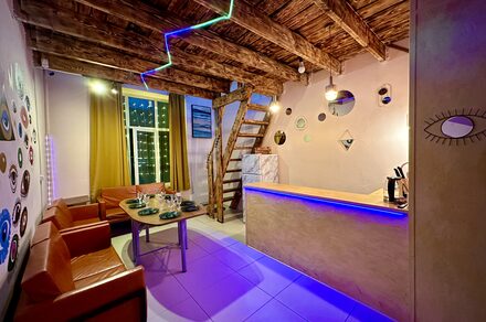 Яркий двухуровневый лофт. Светлая атмосфера. Барная стойка. Стол с посудой, диваны.. Лестница на второй этаж. Разукрашенные стены