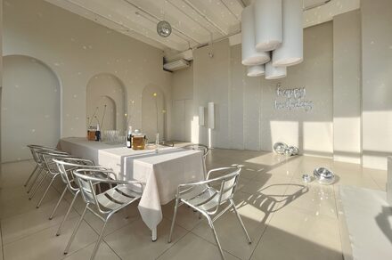 Роскошный панорамный лофт . Пурпурно-розовое освещение. Небольшая сцена. Телевизор с колонками. Диванчик со стульями и небольшим столиком