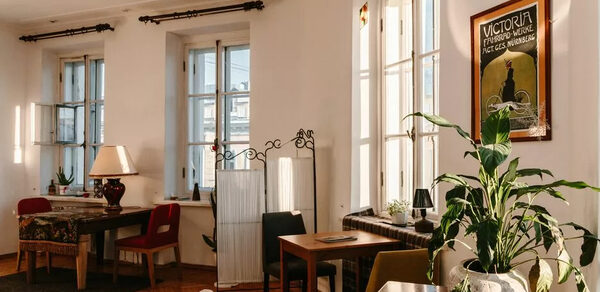 Светлый лофт с панорамным видом. Большие окна. Столы с лампой и цветком, стулья