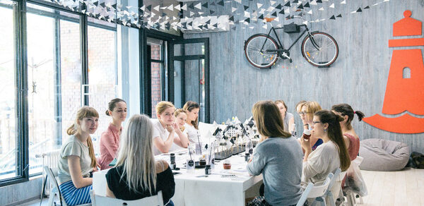 Стильный лофт в скандинавском стиле. Вход с улицы. Девушки за общим столом в лофте на празднике. 
