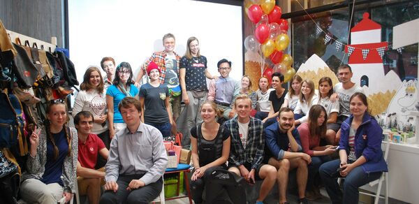 Стильный лофт в скандинавском стиле. Вход с улицы. Общее фото гостей на память во время праздника в лофте, гости сидят и стоят.