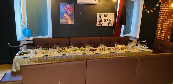 Караоке-бар в центре города. Диваны с небольшими квадратными столами. Телевизор. Гирлянда