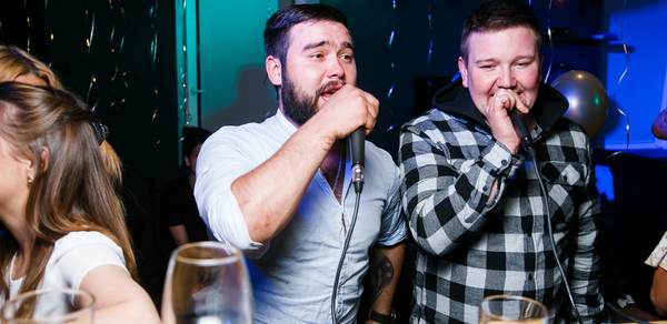 Караоке-бар в центре города. Мужчина и девушка поют в караоке