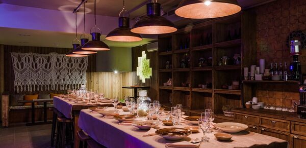 Нора. Оборудованный зал. Затемнённое освещение. Столы с сервировкой. Подвесные лампы