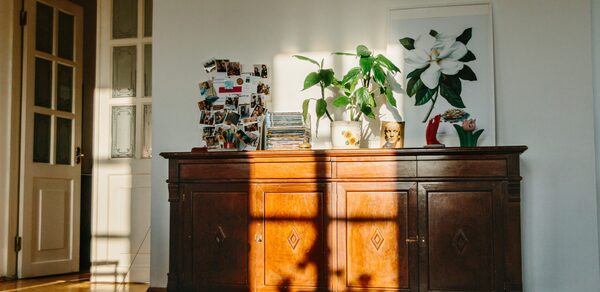 Светлый лофт с панорамным видом. Тумбочка с цветком, книгами, картиной