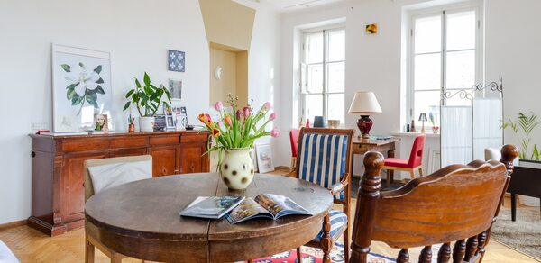 Светлый лофт с панорамным видом. Светлый зал. Круглый стол с цветком и журналами