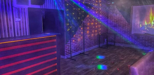 Forest(Лес). Кирпичные стены с деревянной панелью, стойка с подсветкой, деревянный пол, потолочные светильники, лазерное освещение, светодиодный проектор с изображением камина.