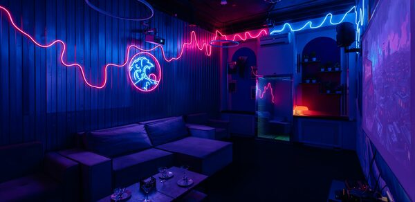 Rubin Loft (Рубин Лофт). Зал Токио. Караоке-комната с неоновыми огнями на стенах, диванами вдоль стен, невысоким столом, проектором, синим и фиолетовым освещением. Стены облицованы панелями, потолок темный, есть зеркальный шар.