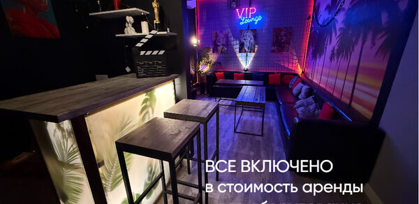 Лофт ИЗНАНКА. Зал ГОЛЛИВУД. Лаунж-зона с барной стойкой и высокими стульями, мягкими диванами вдоль стены, неоновая надпись "VIP Lounge", декоративная подсветка, изображения на стене, пол темный и деревянный, надпись "ВСЕ ВКЛЮЧЕНО".