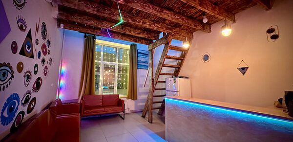 Яркий двухуровневый лофт. Диваны. Барная стойка. Лестница на второй этаж. Холодильник