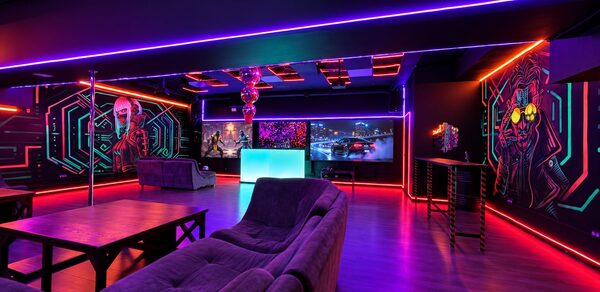 Cyberpunk (Киберпанк). Лофт с неоновым освещением, барной стойкой, диванами и столами. На стенах граффити с неоновыми акцентами. Потолок украшен светящимися панелями, пол светлого дерева. Светодиодные ленты подчеркивают элементы интерьера.