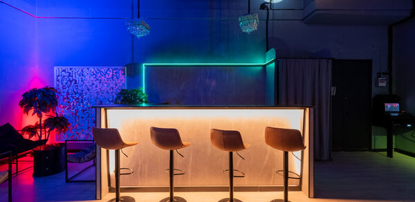 Неоновый лофт-зал с барной стойкой и сценой