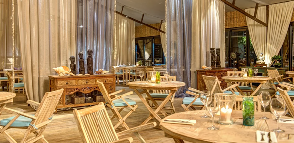 Soho Country Club (Сохо Кантри Клаб). Зал с деревянными столами и складными стульями с подушками. Деревянные комоды, декоративные статуи. Пол—дерево, стены декорированы тканевыми занавесками. Теплое освещение, расставлены свечи и бокалы.