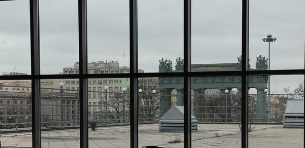 Студия Н. Современное остеклённое пространство с видом на город, большое окно от пола до потолка. В комнате бильярдный стол с зелёным сукном и шаром. Снаружи видно террасу с фонарями и фрагменты городской архитектуры.