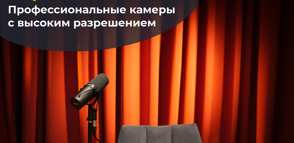 Лофт  Эйфория. Стол с микрофоном на подставке, серый стул, фон из красных штор. Надпись: «Картинка 4К. Профессиональные камеры с высоким разрешением».