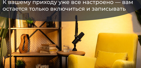 Лофт  Эйфория. Студия с жёлтым креслом, рядом круглый стол с чёрным микрофоном, книгой и стаканом. Слева стеллаж с книгами, растениями и декоративными элементами. Стена светлая, освещение тёплое. На стене текст: «Забудьте про суету...»