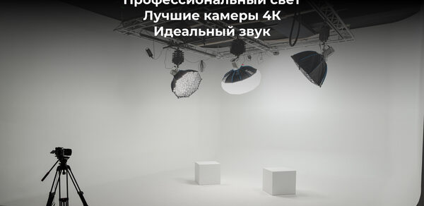 Лофт Циклорама. Белая циклопорама с двумя кубами, установлены три студийных осветительных прибора на потолочной конструкции, штатив. Текст на черном фоне: "Белая циклопорама с декором, Профессиональный свет, Лучшие камеры 4К, Идеальный звук".