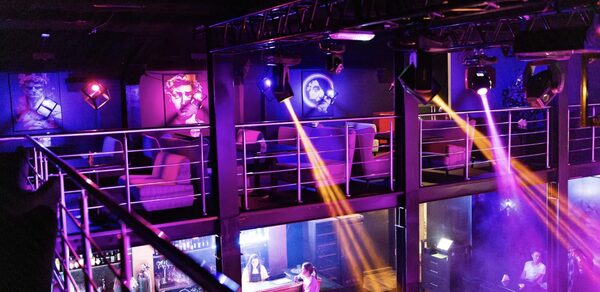 Castle Concert Hall(Концертный зал Замок). Двухуровневое пространство с металлическими перилами, пуломанами и барной стойкой; фиолетовое и розовое освещение; стены декорированы портретами; на верхнем уровне зоны для отдыха; видны световые эффекты.