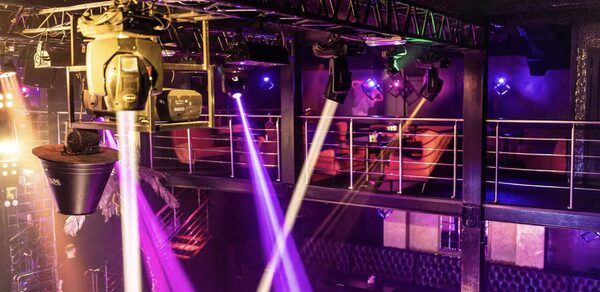 Castle Concert Hall(Концертный зал Замок). Многоуровневое пространство для мероприятий, с металлическими перилами и сидячими местами на втором этаже. Световое оборудование, разноцветные прожекторы и лучи. Декор в тёмных тонах, кожаная мебель. Индустриальные элементы в дизайне.