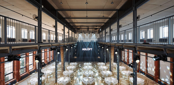 AG LOFT. Grand Hall (АГ Лофт. Большой зал) . Большое открытое пространство с высоким потолком и металлическими балками, круглыми столами с белыми скатертями и стульями. Внизу сцена с подсветкой и мониторами. Многоуровневое расположение с балконом. Стены из красного кирпича с большими окнами. Надпись "AGLOFT".