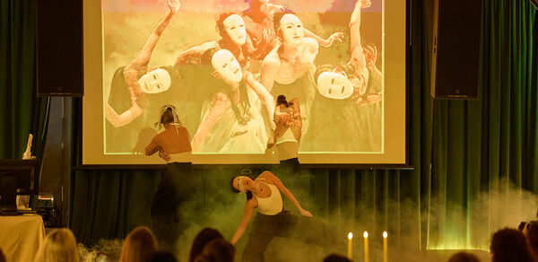 Arsenal Loft(Арсенал Лофт). Актовый зал с проектором, зелёные занавески, танцоры в масках, дымовая машина, зрители на стульях с золотыми спинками, свечи на столе.