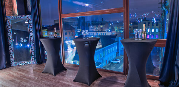 Стильный панорамный лофт на Петроградке. Dj за микшерным пультом. На втором плане люди танцуют