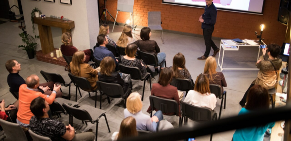 Стильный двухуровневый лофт. Парень играет в "бирпонг". На втором плане общаются люди