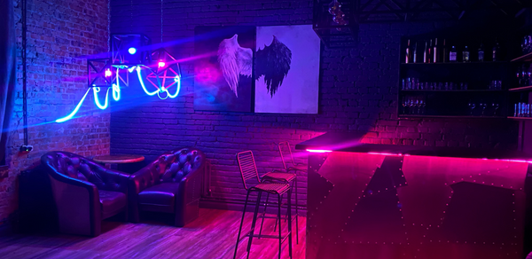 Контраст Loft. Приглушённый тёплый свет. Диваны. Стол. Кресла. Лестница на второй этаж 