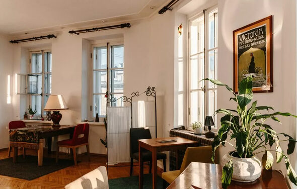 Светлый лофт с панорамным видом. Большие окна. Столы с лампой и цветком, стулья