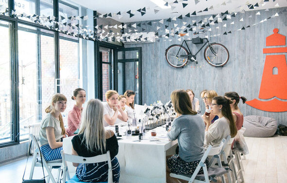 Стильный лофт в скандинавском стиле. Вход с улицы. Девушки за общим столом в лофте на празднике. 