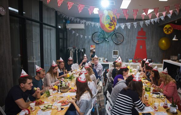 Стильный лофт в скандинавском стиле. Вход с улицы. Праздничный стол на день рожденья, гости в бумажных колпаках.