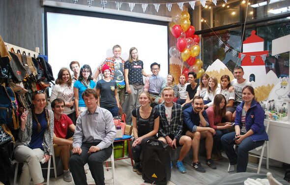 Стильный лофт в скандинавском стиле. Вход с улицы. Общее фото гостей на память во время праздника в лофте, гости сидят и стоят.