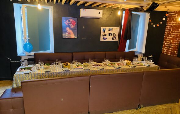 Караоке-бар в центре города. Диваны с небольшими квадратными столами. Телевизор. Гирлянда