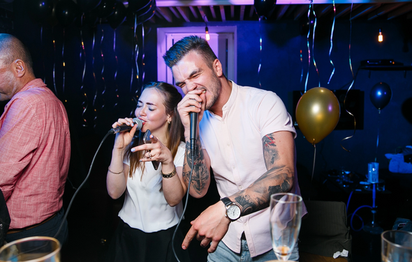 Караоке-бар в центре города. Барная стойка с барными стульями. Большие колонки. Телевизор. Чёрная кирпичная стена с нарисованной Джессикой Рэббит