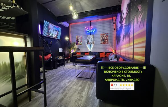 Лофт ИЗНАНКА. Зал ГОЛЛИВУД. Лофт-пространство с диванами и столиками, барная стойка, подвесное освещение, неоновая вывеска "VIP lounge", яркие фото на стене, деревянный пол, темные стены, крупный экран телевизора, текстовое объявление о наличии оборудования.