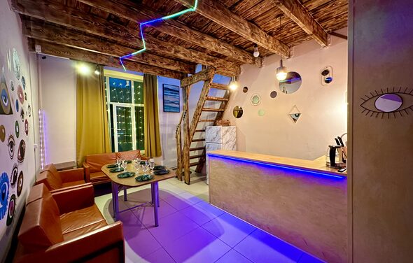 Яркий двухуровневый лофт. Светлая атмосфера. Барная стойка. Стол с посудой, диваны.. Лестница на второй этаж. Разукрашенные стены