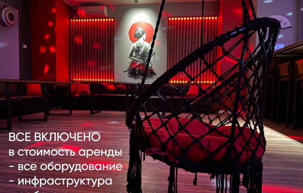 Лофт ИЗНАНКА. Зал ТОКИО. Пространство с подвесным креслом, креслом-мешком, столами вдоль стены, которое украшает картина. Настенный декор с подсветкой. Красные неоновые элементы освещения. Текст: «Все включено в стоимость аренды - все оборудование - инфраструктура».