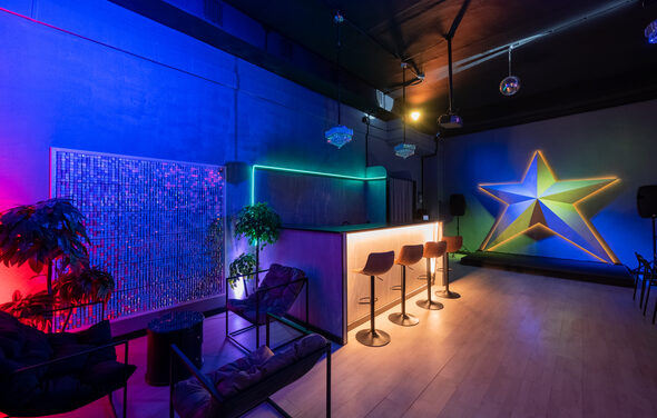 Неоновый лофт-зал с барной стойкой и сценой