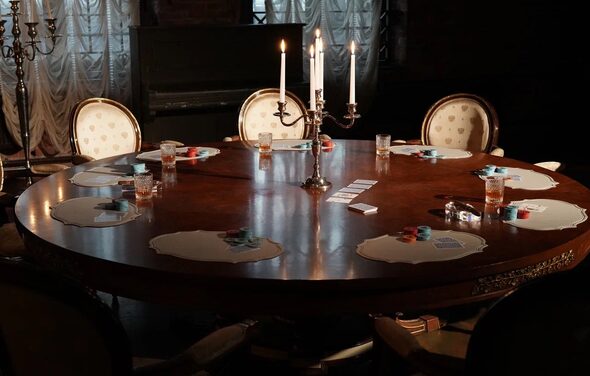 Polygon(Полигон). Зал Апартаменты. Круглый деревянный стол с резными деталями, окружён шестью стульями с белой обивкой. На столе игральные карты, фишки и стаканы с напитками. В центре подсвечник с зажженными свечами. На заднем плане тёмная занавеска и фортепиано. Освещение тусклое.