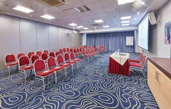 Зал для деловых мероприятий с ковролином и мягкими стульями