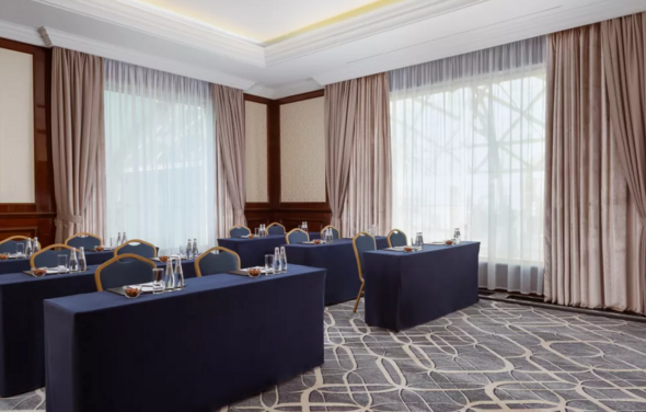 Зал с панорамными окнами и строгим интерьером