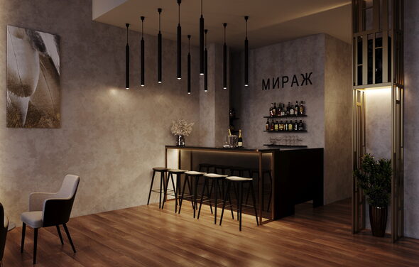 Лофт Мираж. Барное пространство с барной стойкой и высокими стульями на деревянном полу. Стены светло-серые, украшены картиной. Потолочные подвесные светильники. На стене надпись «МИРАЖ». На полках за стойкой бутылки и бокалы. Рядом одно кресло и растение.