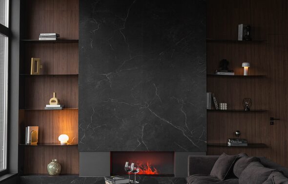 Зал Black. Фотостудия Мимика. Гостиная с тёмной каминной зоной, большая чёрная плита. Открытые полки с книгами и декором. Угольная мебель, мягкий диван. Лампы тёплого света, стеклянный столик с бокалами. Отделка тёмного дерева, окно слева.