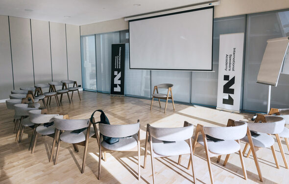 Лекторий на 53 этаже Москва-Сити - 100 м², до 35 человек. Современная конференц-комната с круговой расстановкой стульев, проекционный экран, два рекламных стенда, флипчарт, деревянный пол, раздвижные стены светлых тонов, панорамные окна с затемнением.