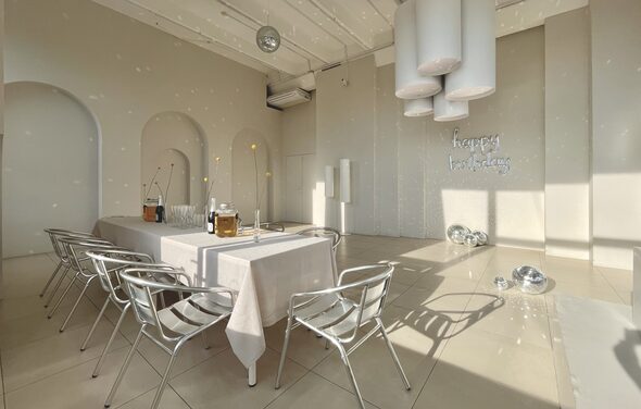 Роскошный панорамный лофт . Пурпурно-розовое освещение. Небольшая сцена. Телевизор с колонками. Диванчик со стульями и небольшим столиком