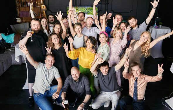 Стильный панорамный лофт на Петроградке. Коллектив людей, сидящих за столами и играющих в "мафию"