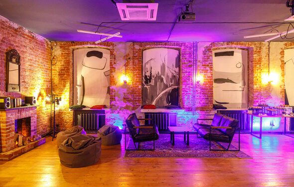 Citrus Hall(Цитрус Зал). Grapefruit(Грейпфрут) . Лофт-пространство с кирпичными стенами, большими окнами, настенными картинами и мягким фиолетовым освещением. Мебель: кресла, пуфы, стол, ковёр. Деревянный пол, камин, открытые трубы и подвесные светильники. Встроенный кондиционер на потолке.